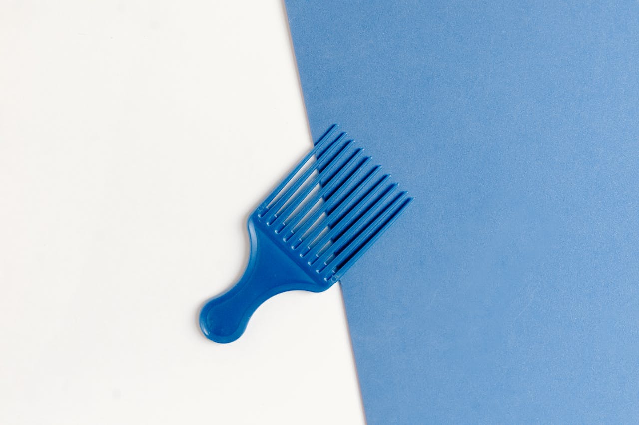 services-03 Stylish blue plastic comb on a dual-tone white and blue background.